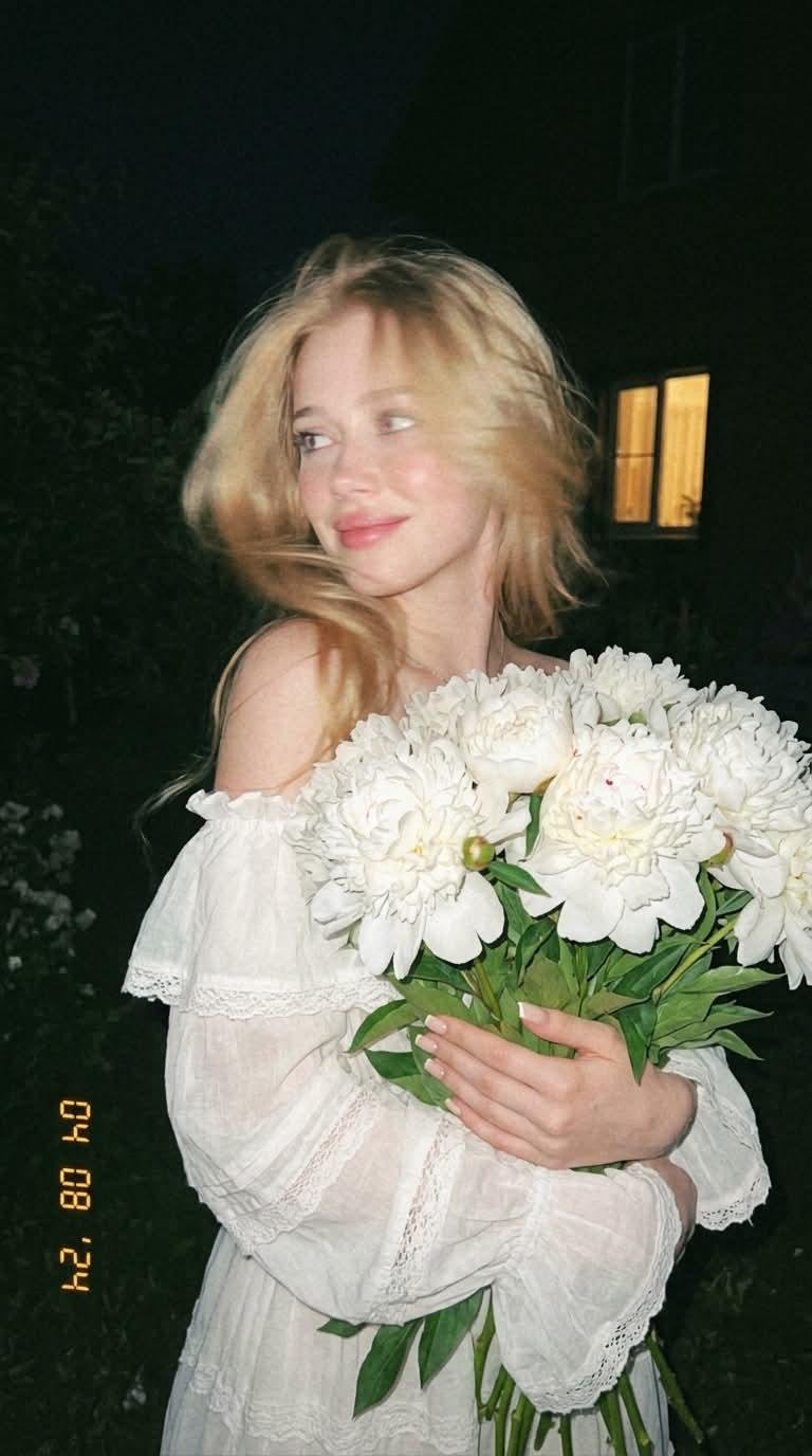 blonde woman with white peonies night garden flash