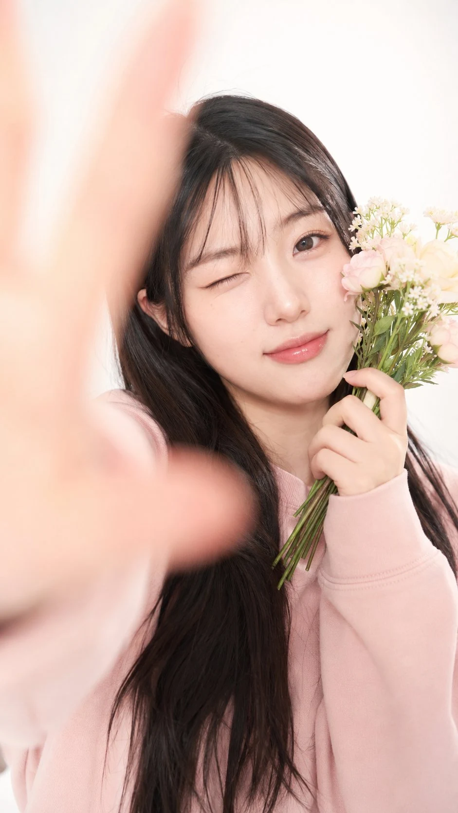 Korean girl winking with flowers pink hoodie studio