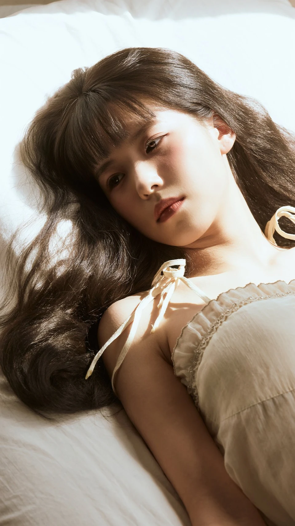 Soft dreamy portrait of young East Asian woman lying