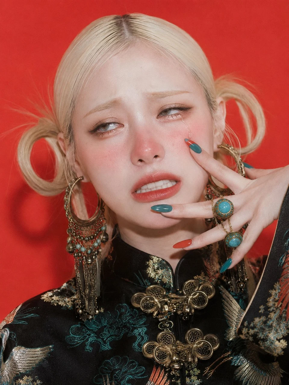 Blonde woman in embroidered dress against red
