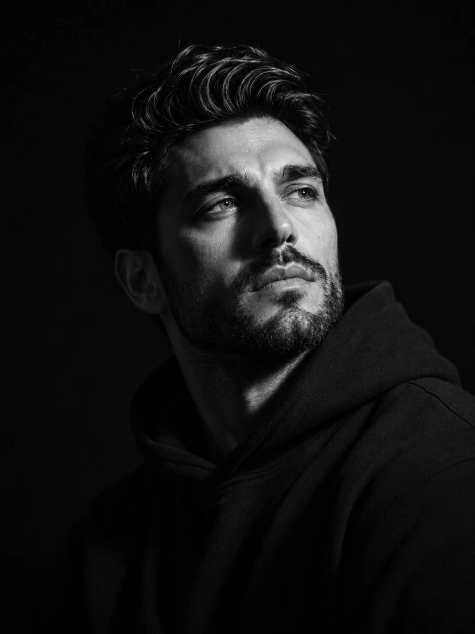 Moody black and white studio portrait of bearded man