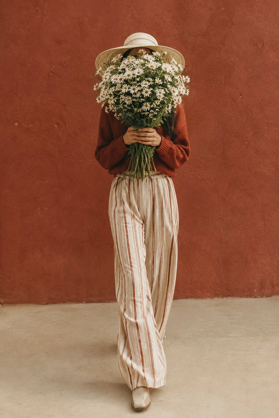 Fashion woman holding daisy bouquet in autumn tones