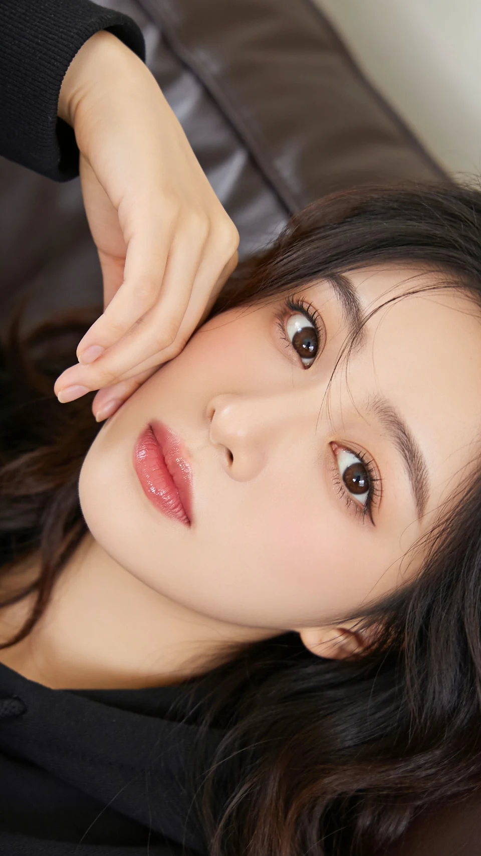 young East Asian woman resting head on hand close-up